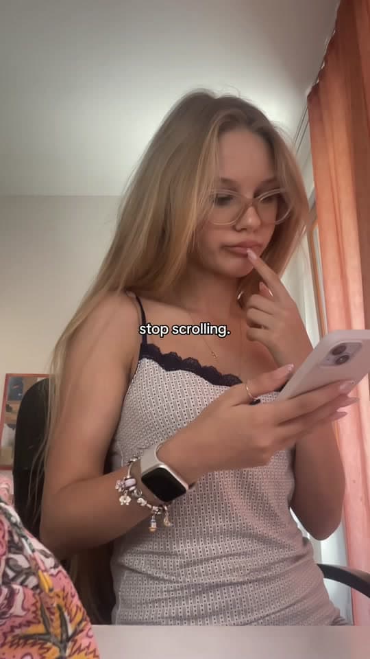 Creator looking at her phone, captioned “stop scrolling.”
